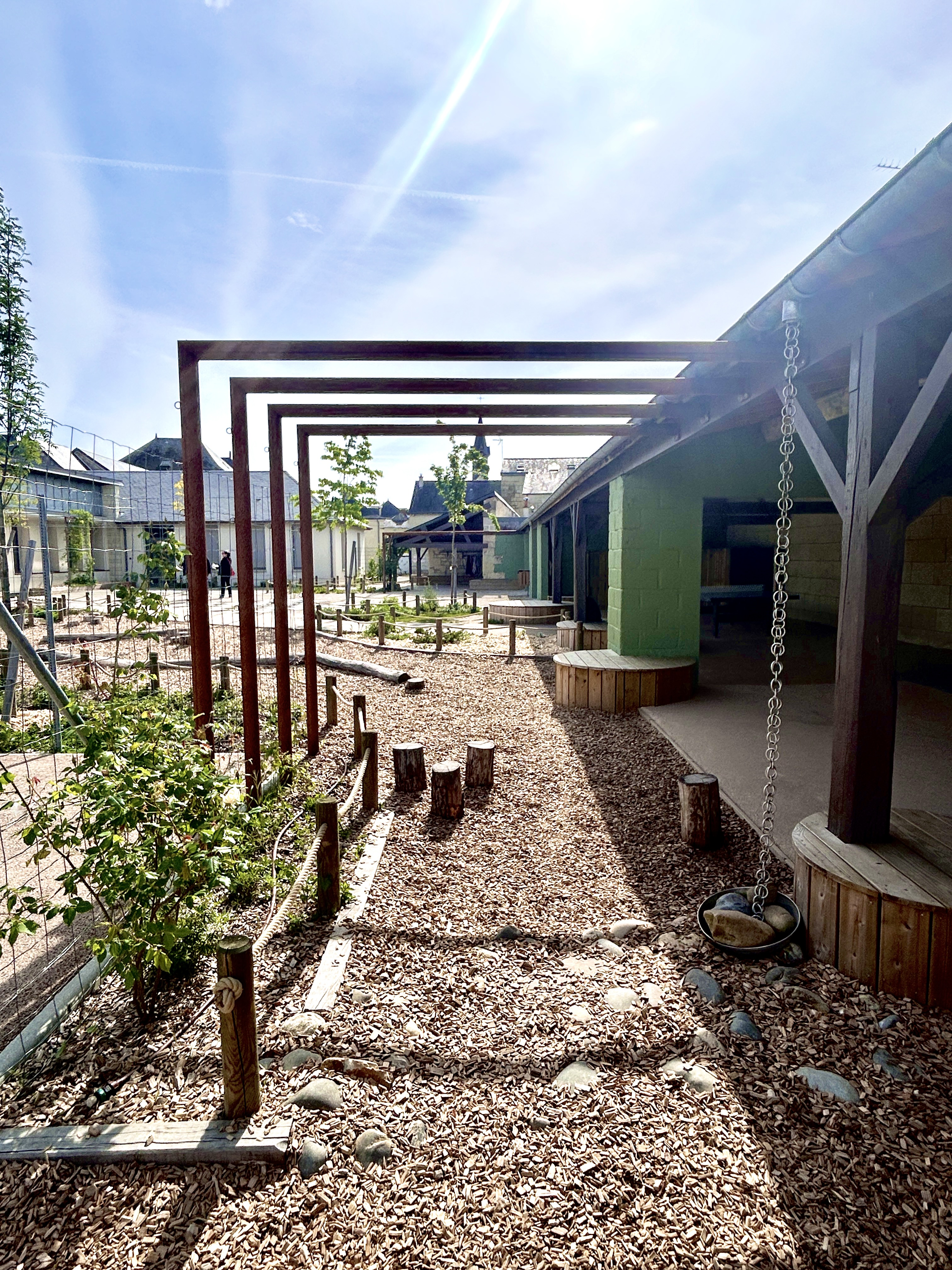 Structure métallique végétalisée bordant un parcours naturel dans la cour d’école